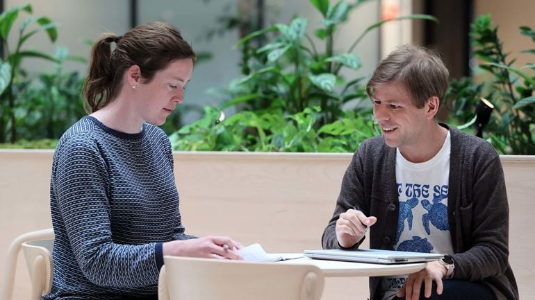 To personer sitter og jobber sammen