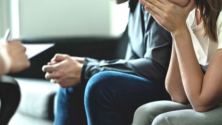 To mennesker sitter i en sofa. Man ser kun hender og ikke ansikt.