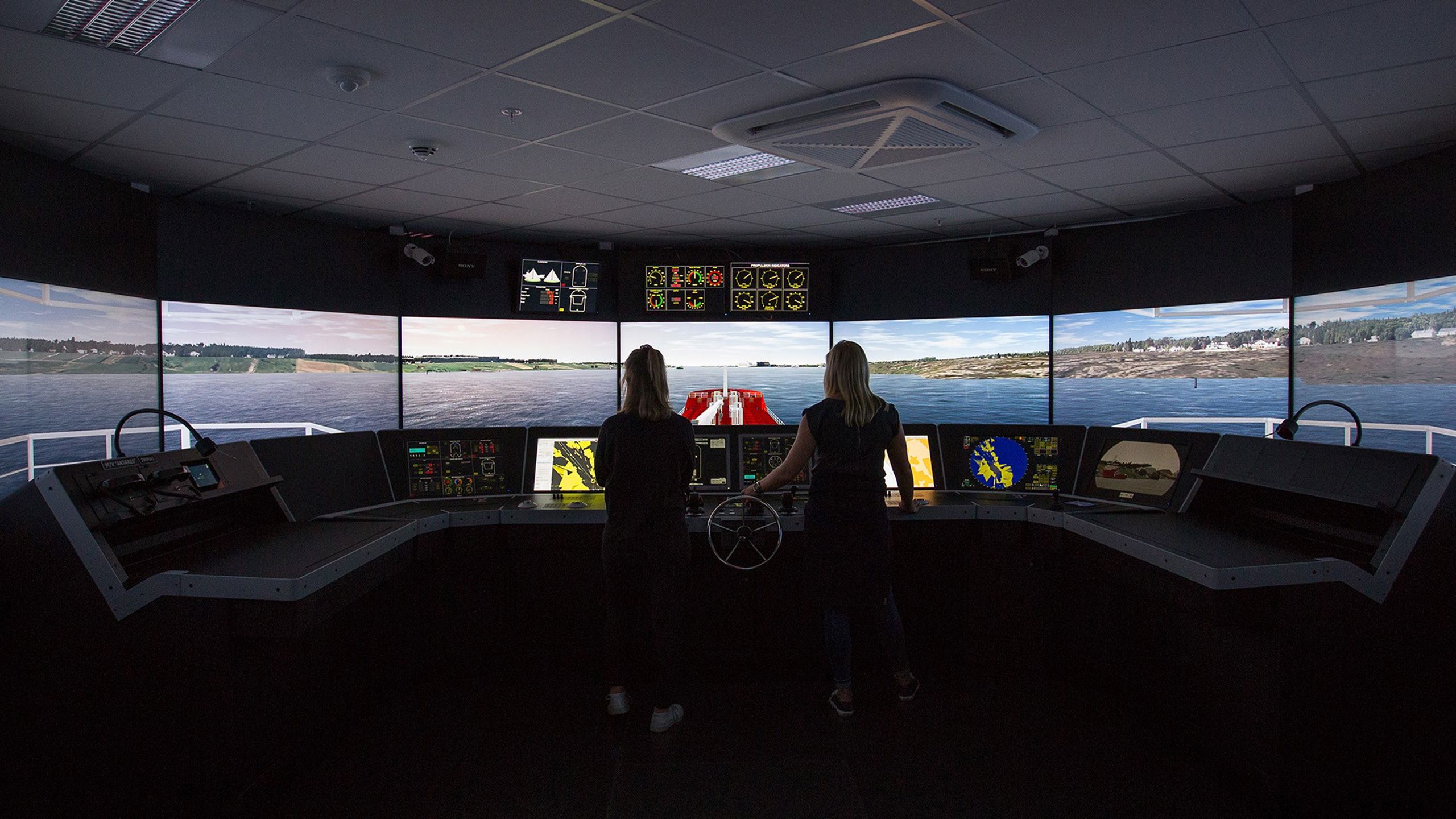 To personer fra innsiden av en båt som styrer mot land