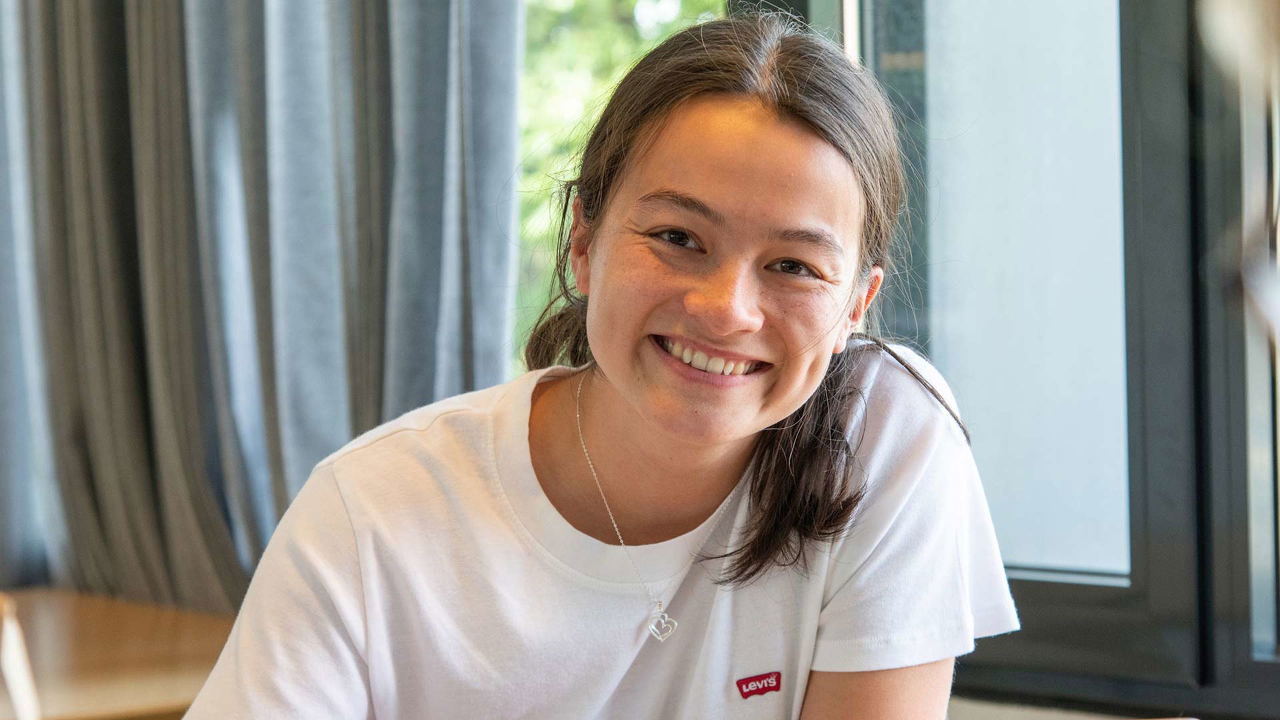 Smilende kvinne som ser i kamera.