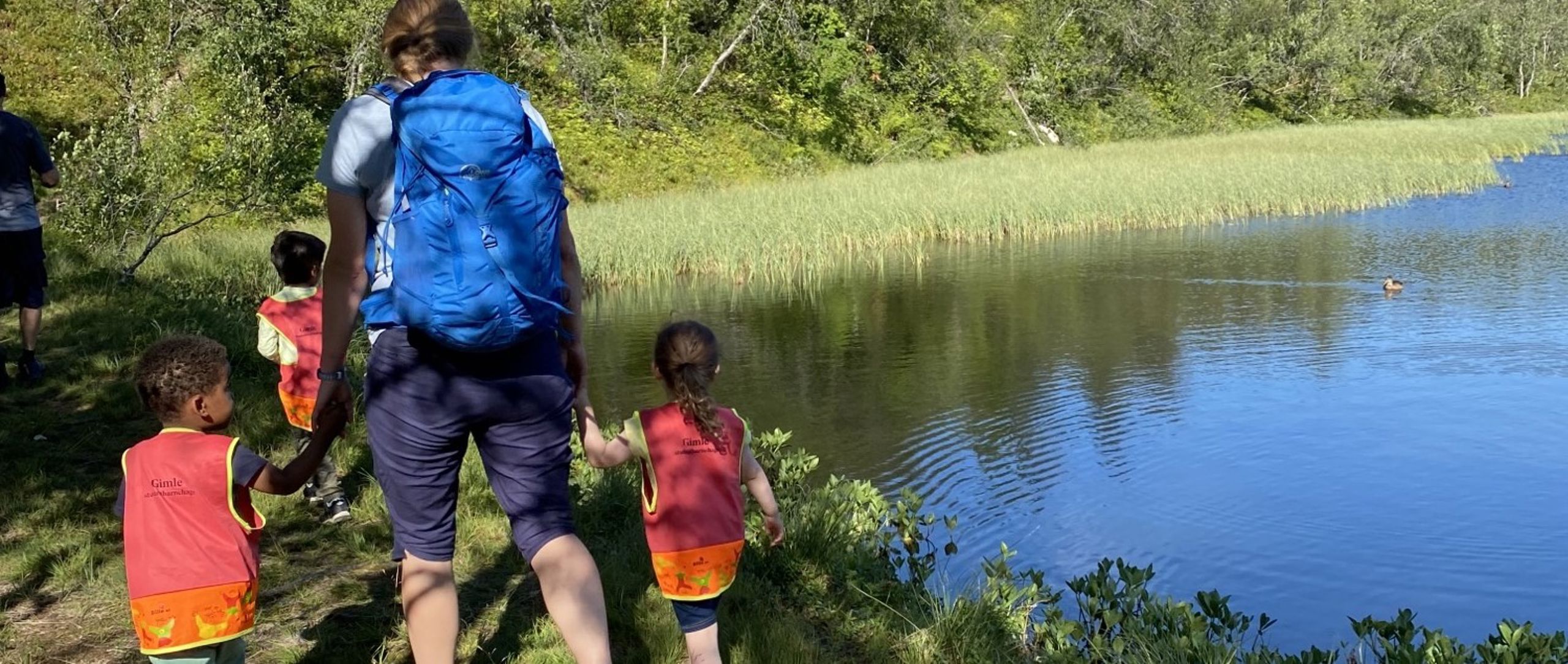 An adult and some children outdoors