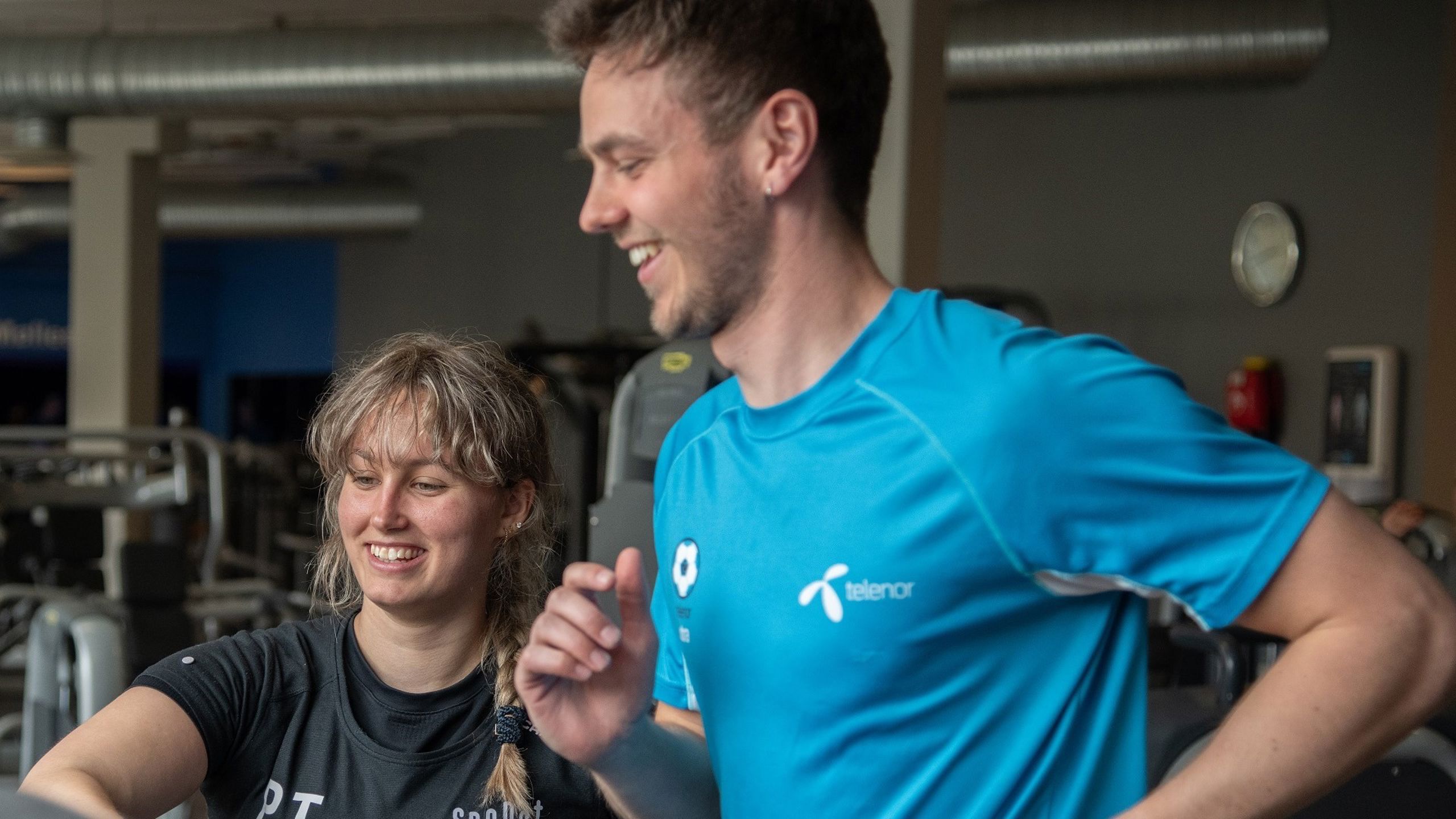 PT-trener sammen med en mann som løper på tredemølle