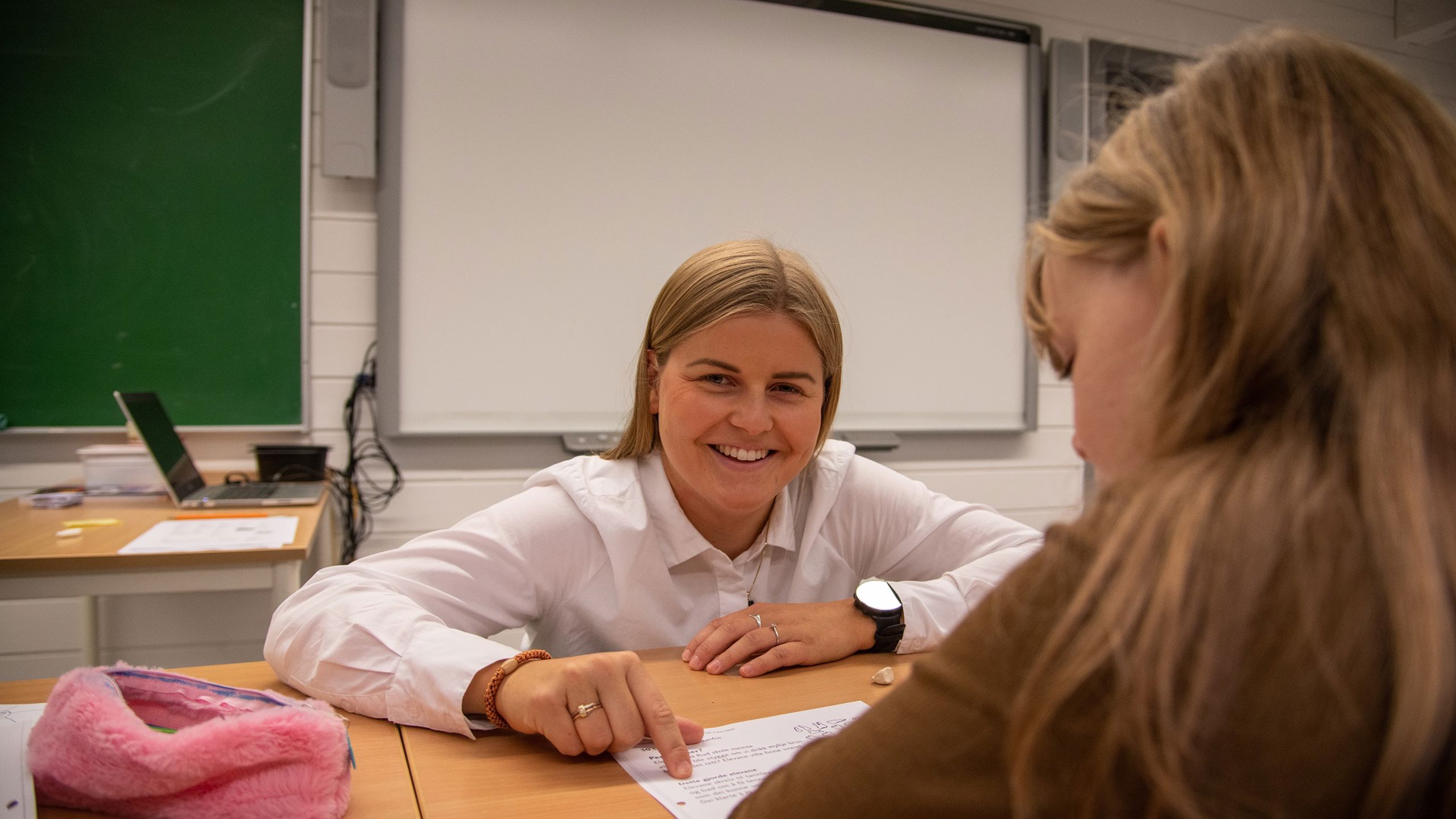 Lærerstudent som hjelper en elev.