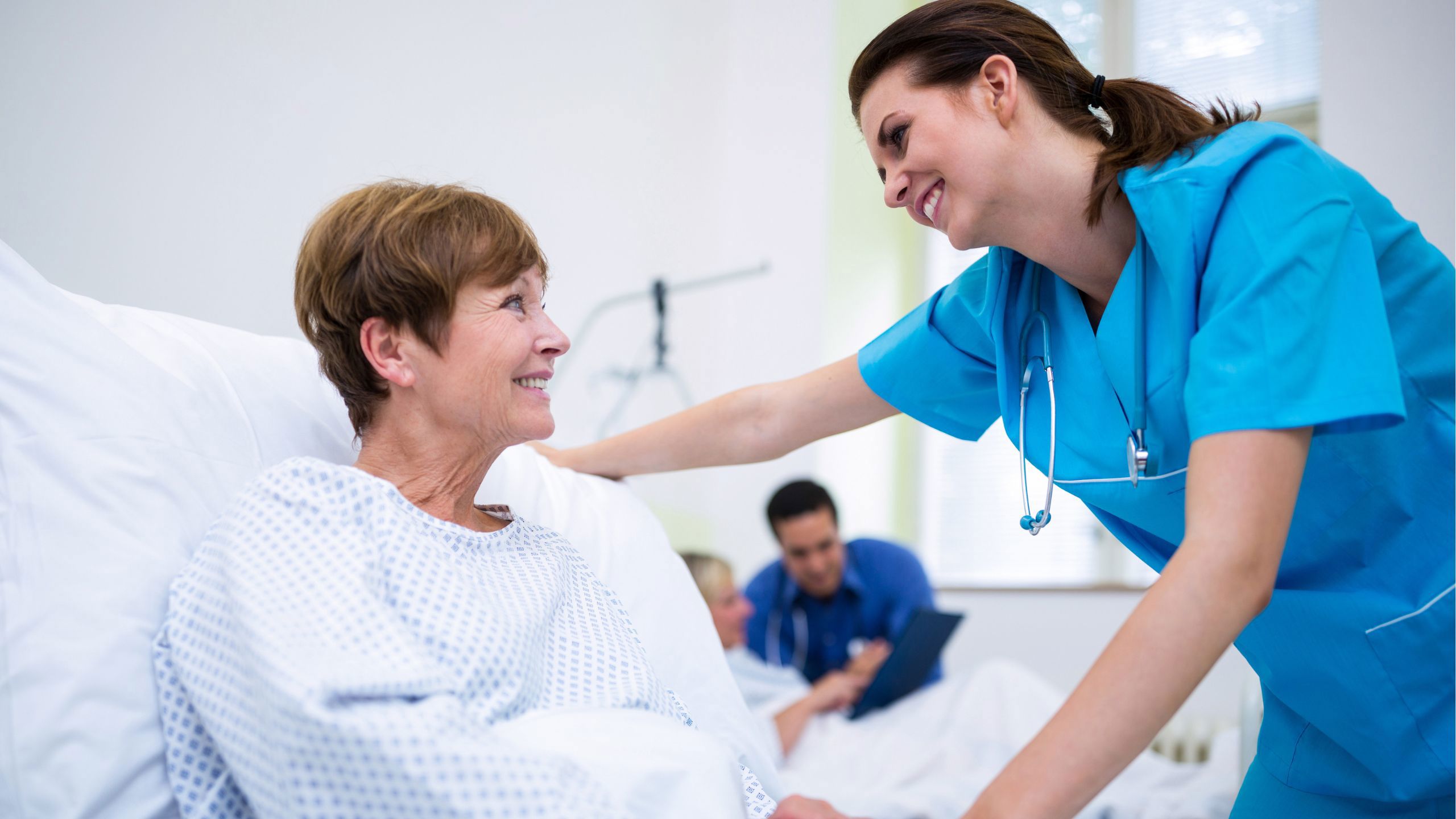 Sykepleier og pasient på sykehuset som smiler til hverandre