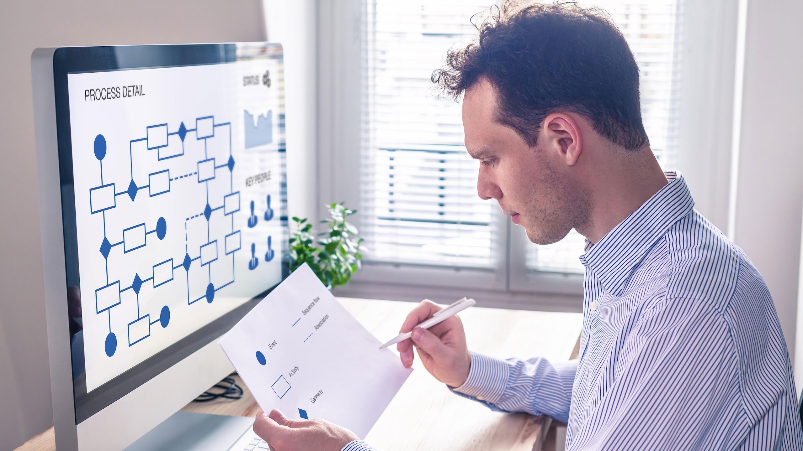 Mann sitter foran en pc.