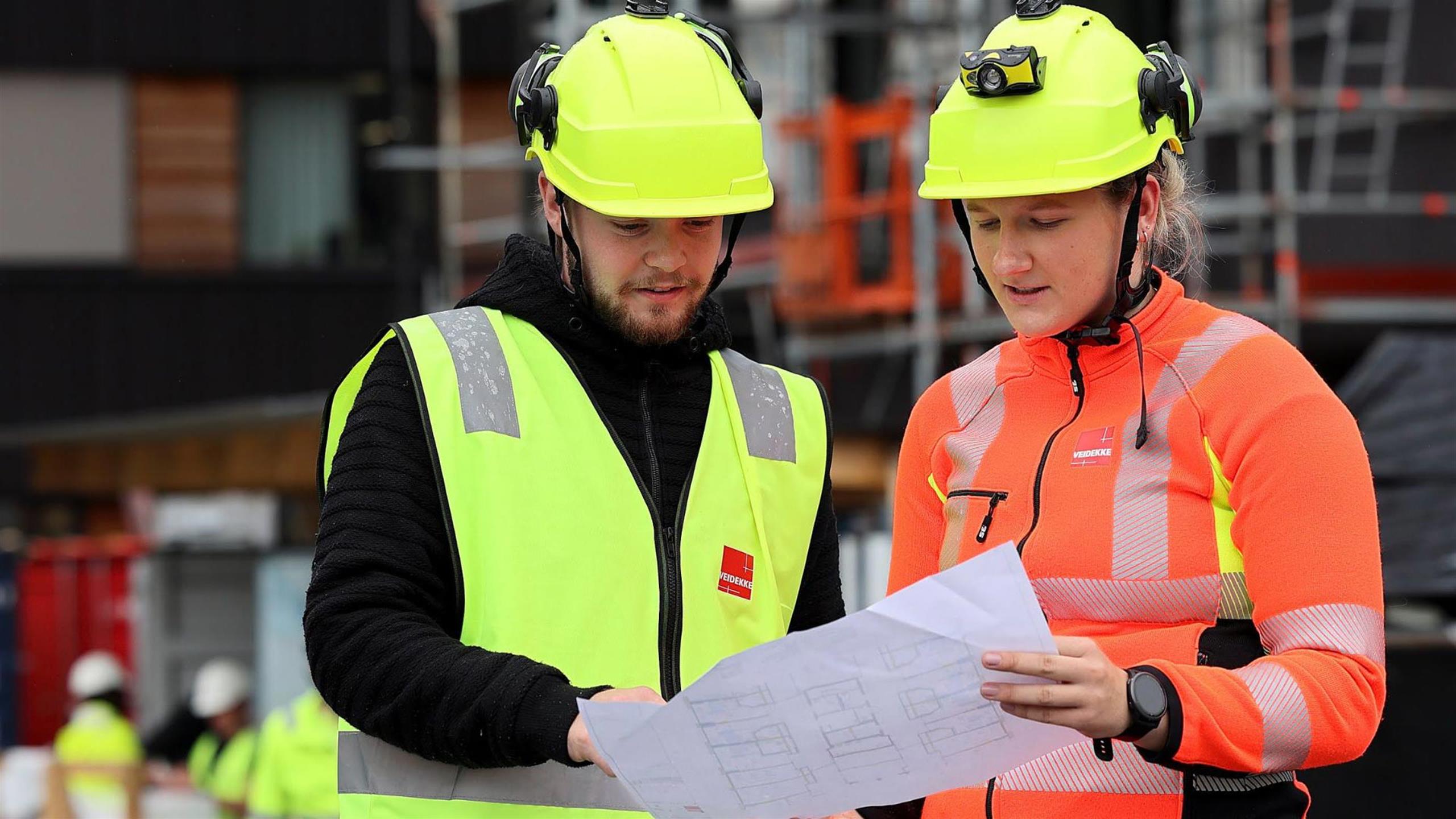 Two employees at a construction site is talking together.