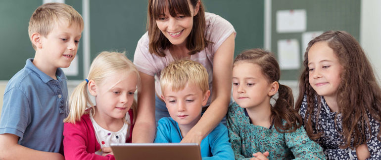 En kvinne står foran en gruppe med barn.