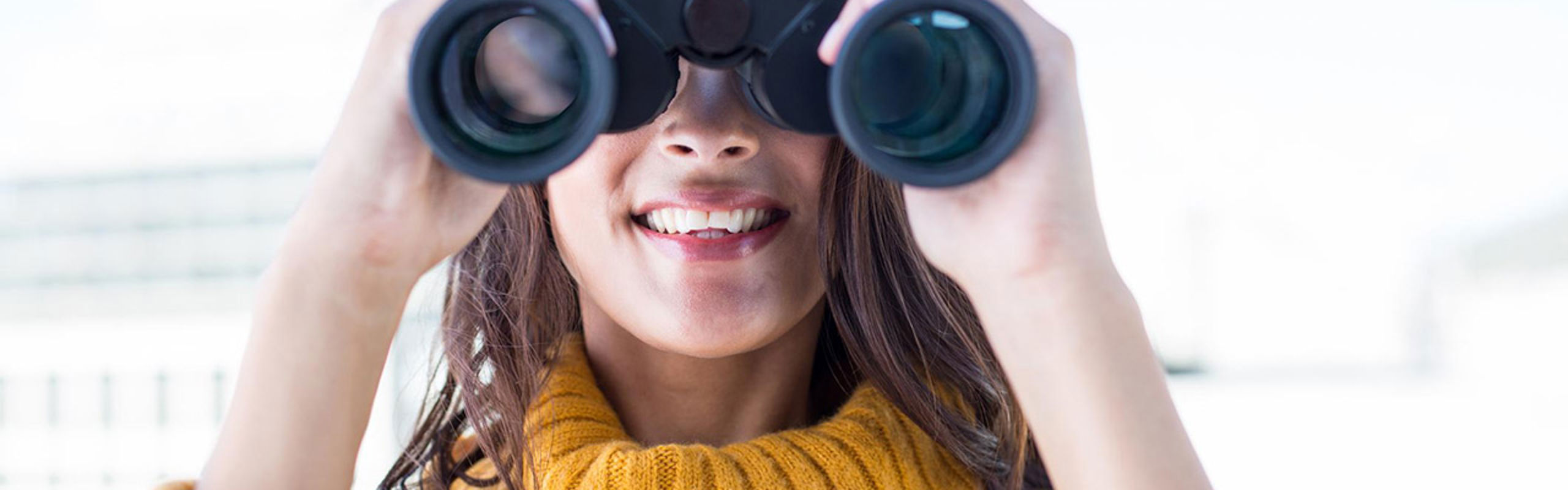 Dame som ser gjennom kikkert.