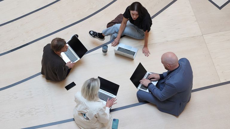 Gruppe på fire med hver sin laptop.