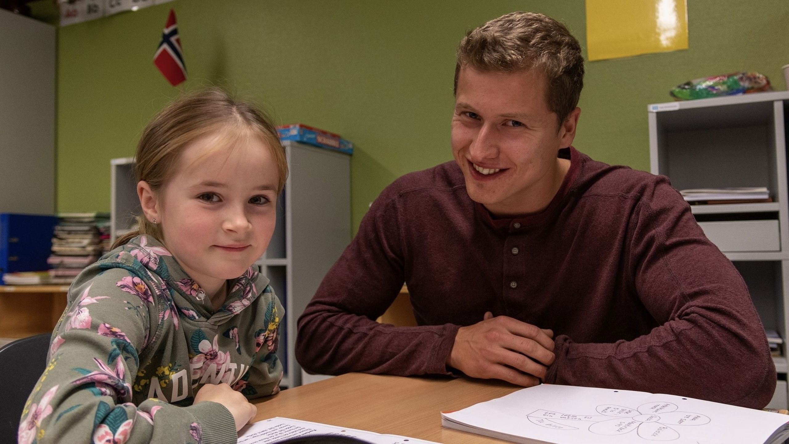 Et barn og en student i klasserommet.