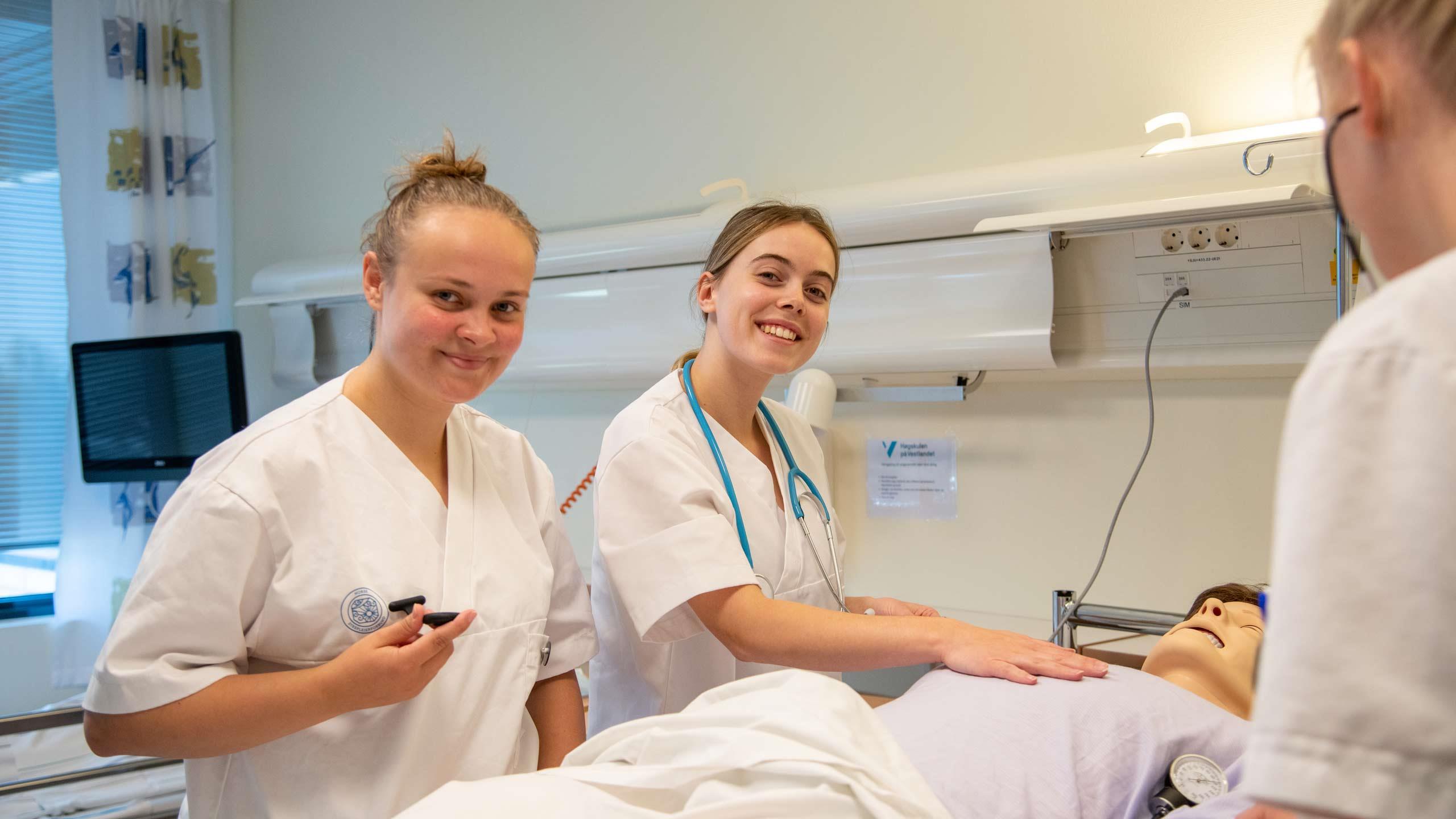 To sjukepleiarstudentar som øver seg på ei testdukke.