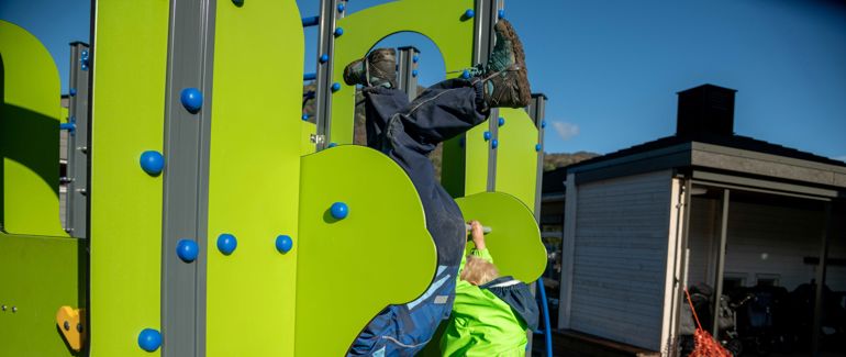 Barn leikar ute i barnehagen.