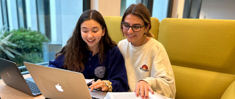 To kvinnnelege studentar med pc.