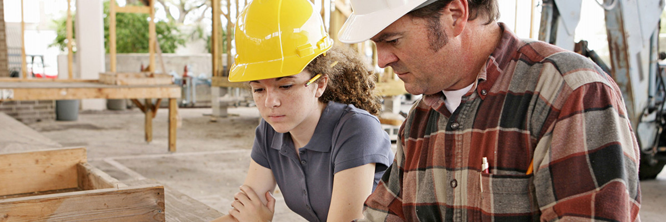 Lærar og elev på yrkesfag med byggeteikningar