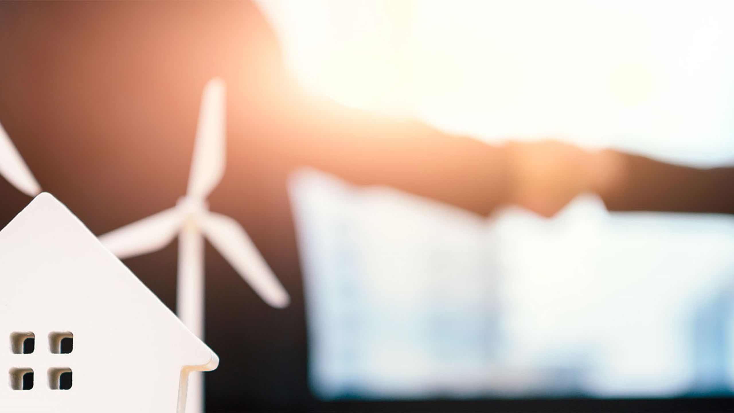 To personer tar hverandre i hånden med en vindmølle i front