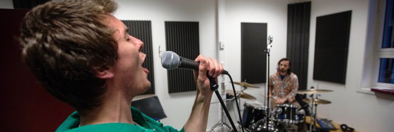 Musikkstudenter synger og spiller i øvingsrom